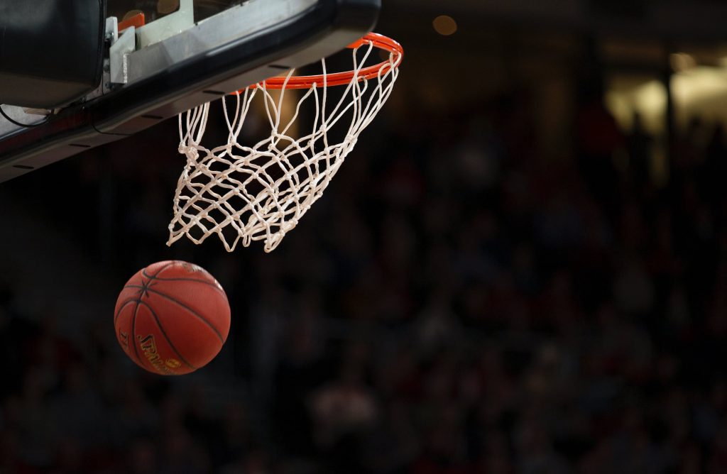 Focused image on basketball going through hoop